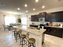 Modern kitchen featuring dark cabinetry and granite countertops at 1012 Anchorage Street, Leesburg, FL 34748