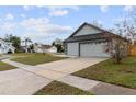 Gray house with a large driveway and a view of the neighborhood at 2201 Kentucky Derby Dr, Orlando, FL 32825