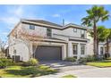 Two-story house with gray accents, a two-car garage, and palm trees at 2639 Calistoga Ave, Kissimmee, FL 34741