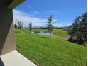 Expansive backyard view featuring a tranquil pond and well-manicured lawn with trees at 2798 Portadown St, Ormond Beach, FL 32174