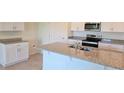 Modern kitchen featuring granite countertops, white cabinetry, and stainless steel appliances at 2798 Portadown St, Ormond Beach, FL 32174