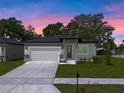 Two-car garage, modern exterior, well-maintained lawn. Evening view at 2920 Lingo Ln, Orlando, FL 32822