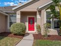 Red front door entrance with landscaping and walkway at 2984 Cedar Glen Pl, Oviedo, FL 32765