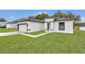 Newly built home with gray roof, white exterior, and a paved walkway at 3999 Sw 129Th St, Ocala, FL 34473