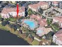 Aerial view of the building including the pool, clubhouse, lake, and surrounding landscaping at 5012 Shoreway Loop # 10207, Orlando, FL 32819