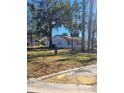 Front view of newly painted house with mature trees and curb appeal at 701 Titcomb St, Eustis, FL 32726