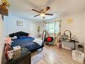 Cozy bedroom with a double bed, ceiling fan, and wood-look floors at 7211 Pinion Dr, Orlando, FL 32818