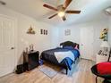 Bedroom with double bed, ceiling fan, and wood-look floors at 7211 Pinion Dr, Orlando, FL 32818