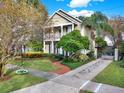 Two-story house with a walkway, landscaping, and a stone driveway at 833 Ellwood Ave, Orlando, FL 32804