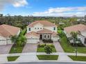 Beautiful two-story home with a tile roof, green lawn and landscaping, and a brick-paved driveway leading to a three-car garage at 8886 Fallen Oak Dr, Davenport, FL 33896