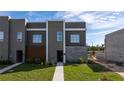 Contemporary townhome boasts a gray facade, stone accents, and landscaped walkway at 9029 Ibiza Ln # 1, Kissimmee, FL 34747