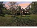 House exterior at dusk, showcasing a landscaped yard and tile roof at 10 Broadwater Dr, Ormond Beach, FL 32174