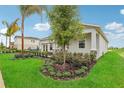 Landscaped side yard with green grass and manicured shrubs at 10140 Huntingnet Way, Leesburg, FL 34748