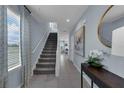 Bright and airy entryway with staircase, wood-look floors, and natural light at 1102 Fan Palm Dr, Davenport, FL 33897