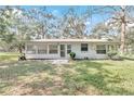 Ranch style home with a screened porch and well-maintained lawn at 11431 Nw 100Th St, Ocala, FL 34482