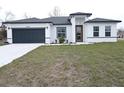 One-story house with gray roof, white walls, and a dark gray garage door at 14511 Sw 29Th Ter, Ocala, FL 34473