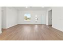 Bright living room featuring wood-look flooring, a large window and a modern front door at 1719 Sw 166Th St, Ocala, FL 34473