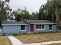 Newly renovated home with red door, gray siding, and landscaped yard at 2104 Newman St, Orlando, FL 32803