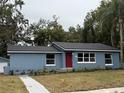 Newly renovated home with red door, gray siding, and landscaped yard at 2104 Newman St, Orlando, FL 32803