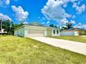 Newly built light green house with a two-car garage, and a large grassy yard at 2645 Sw 155Th Ln, Ocala, FL 34473