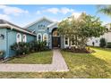 Welcoming front entrance with a brick walkway leading to a charming blue house at 3063 Juneberry Ter, Oviedo, FL 32766