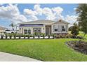 House exterior with a landscaped lawn and awning at 33431 Seattle Slew Dr, Sorrento, FL 32776