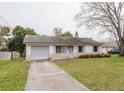 Lovely single-story home with a spacious front yard and driveway leading to the garage at 611 Bay Ave, Holly Hill, FL 32117