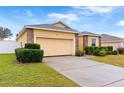 One-story house with a yellow exterior, a two-car garage, and well-manicured landscaping at 841 Greenshank Dr, Haines City, FL 33844