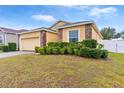 One-story house with a yellow exterior, a two-car garage, and well-manicured landscaping at 841 Greenshank Dr, Haines City, FL 33844