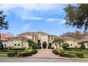 Grand two-story home with a tile roof, palm trees, and manicured landscaping at 9213 Foxhall Ct, Orlando, FL 32819