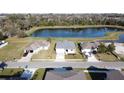 Aerial view showcasing a new single-Gathering home with a pond nearby at 925 Magnolia Ave, Holly Hill, FL 32117