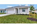 Newly built home features a white exterior, a two-car garage, and a neatly landscaped front yard at 925 Magnolia Ave, Holly Hill, FL 32117