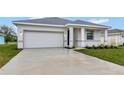 Front view of a newly built home with a two-car garage and well-manicured lawn at 925 Magnolia Ave, Holly Hill, FL 32117