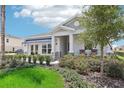 One-story home with gray siding, covered porch, and lush landscaping at 9544 Starling Loop, Leesburg, FL 34788