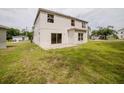 A view of the home's backyard featuring green grass and a concrete patio at 1010 Embrun Ct, Kissimmee, FL 34759