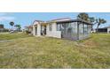 Side view of the house showcasing the screened porch and lawn at 106 Cardinal Dr # D, Ormond Beach, FL 32176