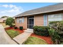 Tan house with blue shutters, walkway, and landscaped yard at 1234 Villa Ln # 142, Apopka, FL 32712