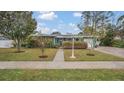 Green house with landscaped yard and walkway at 1296 W Wellington Dr, Deltona, FL 32725