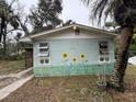 Small house with sunflower mural and a covered patio at 1504 Laun Pl, Lakeland, FL 33803