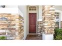 Elegant front entrance with a rich burgundy door and stone accents at 16036 River Pointe Ct, Orlando, FL 32828