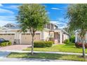 Inviting exterior with a manicured lawn, trees, and neutral stucco with stone accents at 2507 Yellow Brick Rd, St Cloud, FL 34772