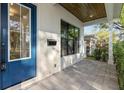 A cozy front porch with a blue door, stone flooring, and views of the neighborhood landscape at 2510 Amherst Ave, Orlando, FL 32804