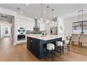 An open-concept kitchen featuring a large center island, stainless steel appliances, and modern pendant lighting at 2510 Amherst Ave, Orlando, FL 32804