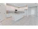 Modern kitchen with white cabinets, granite counters, and island at 33339 Seattle Slew Dr, Sorrento, FL 32776