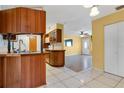 Traditional eat-in kitchen with wood cabinets, tile flooring, and open access to the living area at 4806 Hollyberry Dr, Orlando, FL 32812