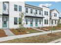 Three-unit townhome building showcasing modern design, landscaping, and a light color scheme at 6581 Quest St, St Cloud, FL 34771