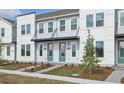 Modern townhome building with light gray siding, green doors, and attractive landscaping at 6581 Quest St, St Cloud, FL 34771