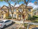 Inviting townhouse exterior with manicured landscaping, mature trees, and dedicated parking at 832 Grand Regency Pt # 102, Altamonte Springs, FL 32714