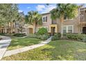 Two-story townhome featuring a manicured lawn and walkway at 8757 Via Tavoleria Way, Windermere, FL 34786