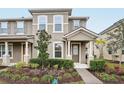 Two-story townhome with neutral siding, landscaped yard, and covered porch at 9457 Randal Park Blvd, Orlando, FL 32832